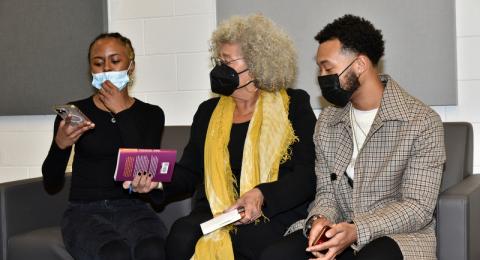 Oswego's 33rd annual Martin Luther King Jr. Celebration keynote speaker Angela Davis, center, signs copies of her book for senior Ziya Myers, who introduced Davis to the audience during the Feb. 9 event, and Marquél Jeffries of the Institute