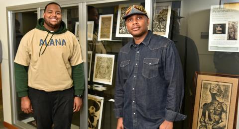 Newton Paul (right) – a 1997 alumnus, art collector and curator of his family's Cuban art collection, pictured with Latino Student Union president Matthews Frank – brought some of his Cuban artwork to campus. 
