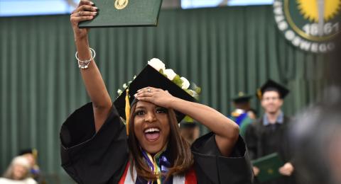 Graduates show their enthusiasm, cheered on by family members and friends in the audience at the December Commencement held Dec. 16. Each graduate's name was announced as they walked across the platform and shook hands with President Peter O. Nwosu. 