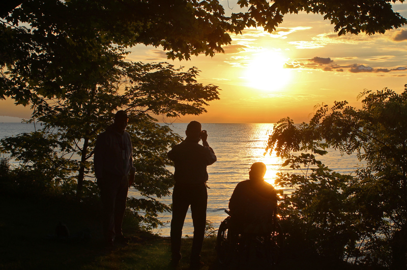 Alumni returning for Reunion admire and take pictures of the Oswego sunset