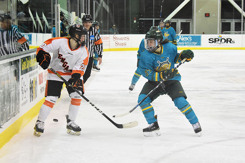 Oswego women's hockey players move the puck in advance of a goal