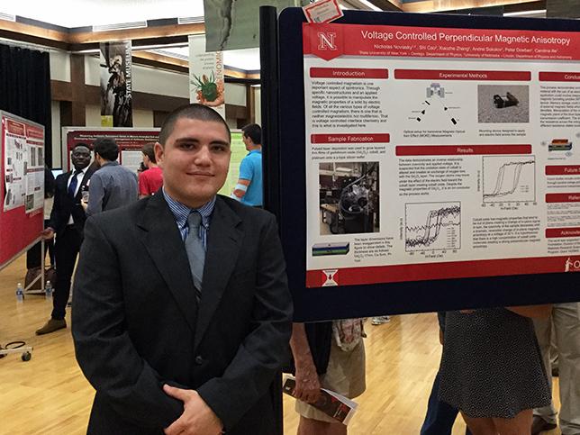 Physics student with poster at conference presentation