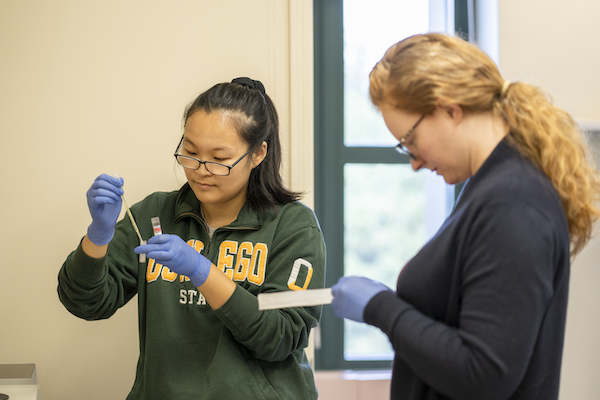 A student and professor in a science lab