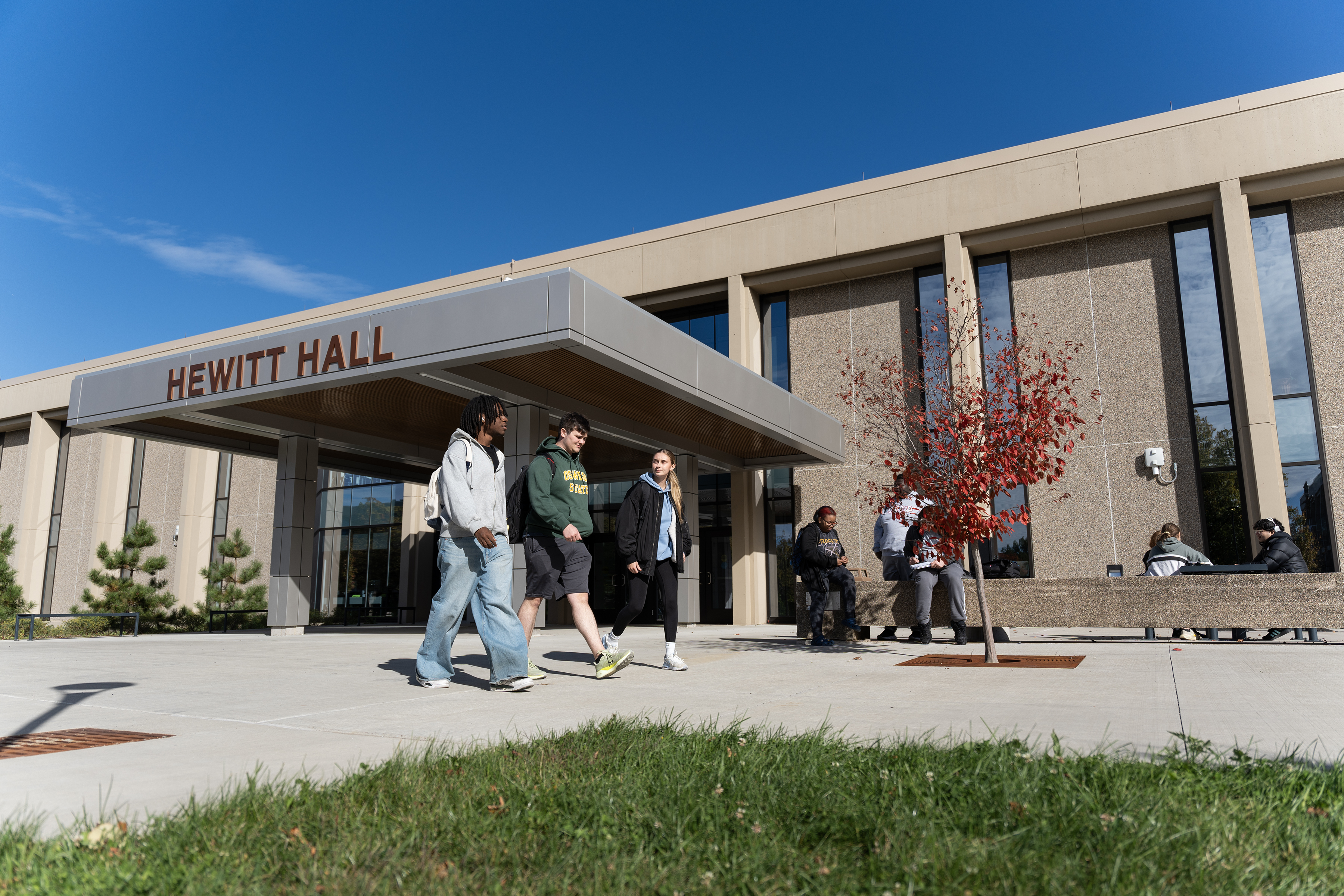Students walking on the sidewalk outside the newly renovated Hewitt Hall