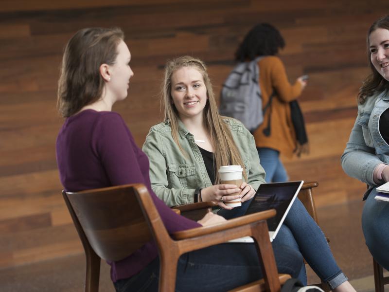 three female students sitting together talking