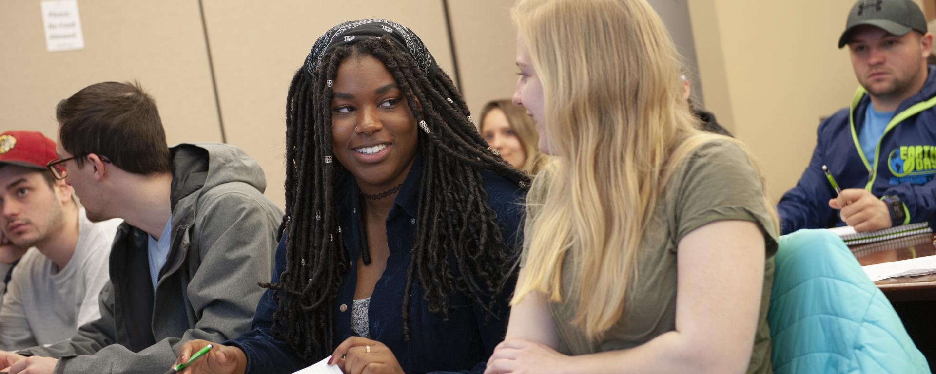 two female students talking in a classroom