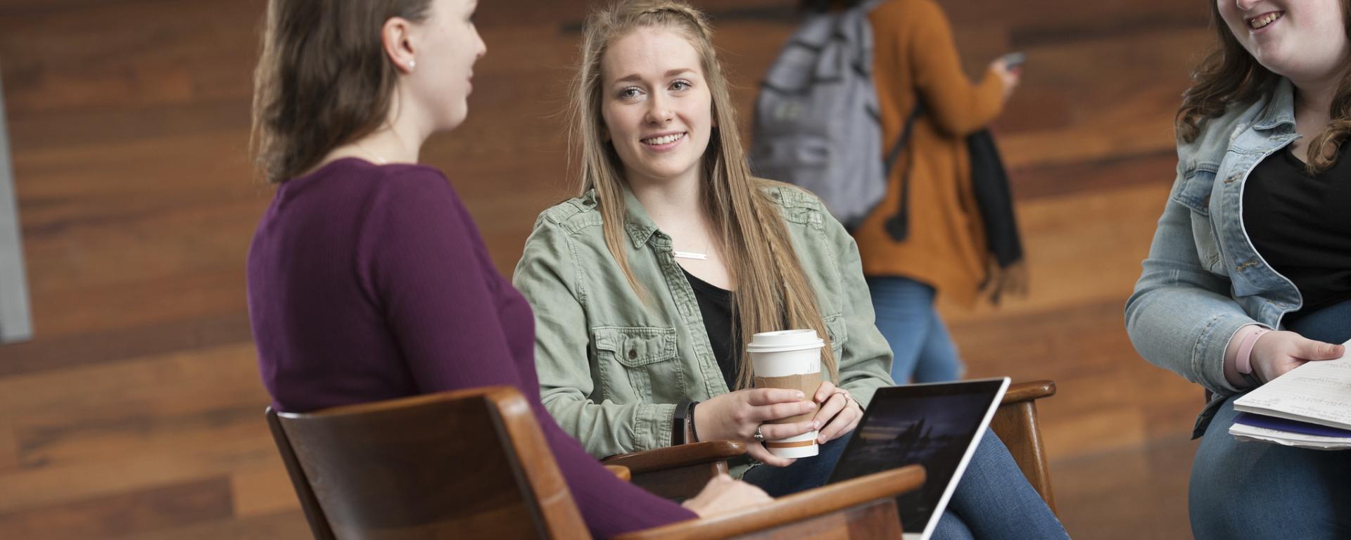 three female students sitting together talking