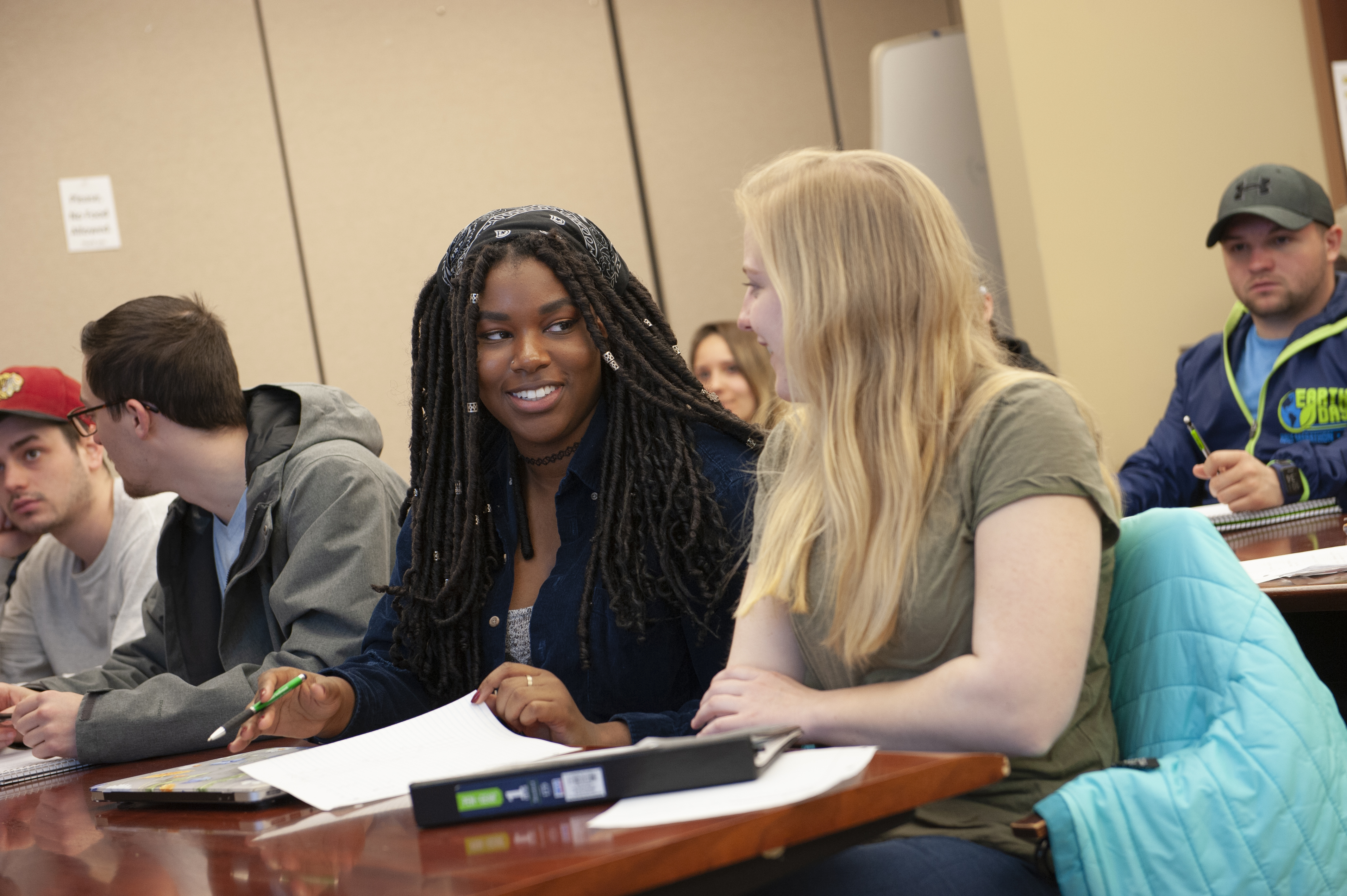 two female students talking in a classroom