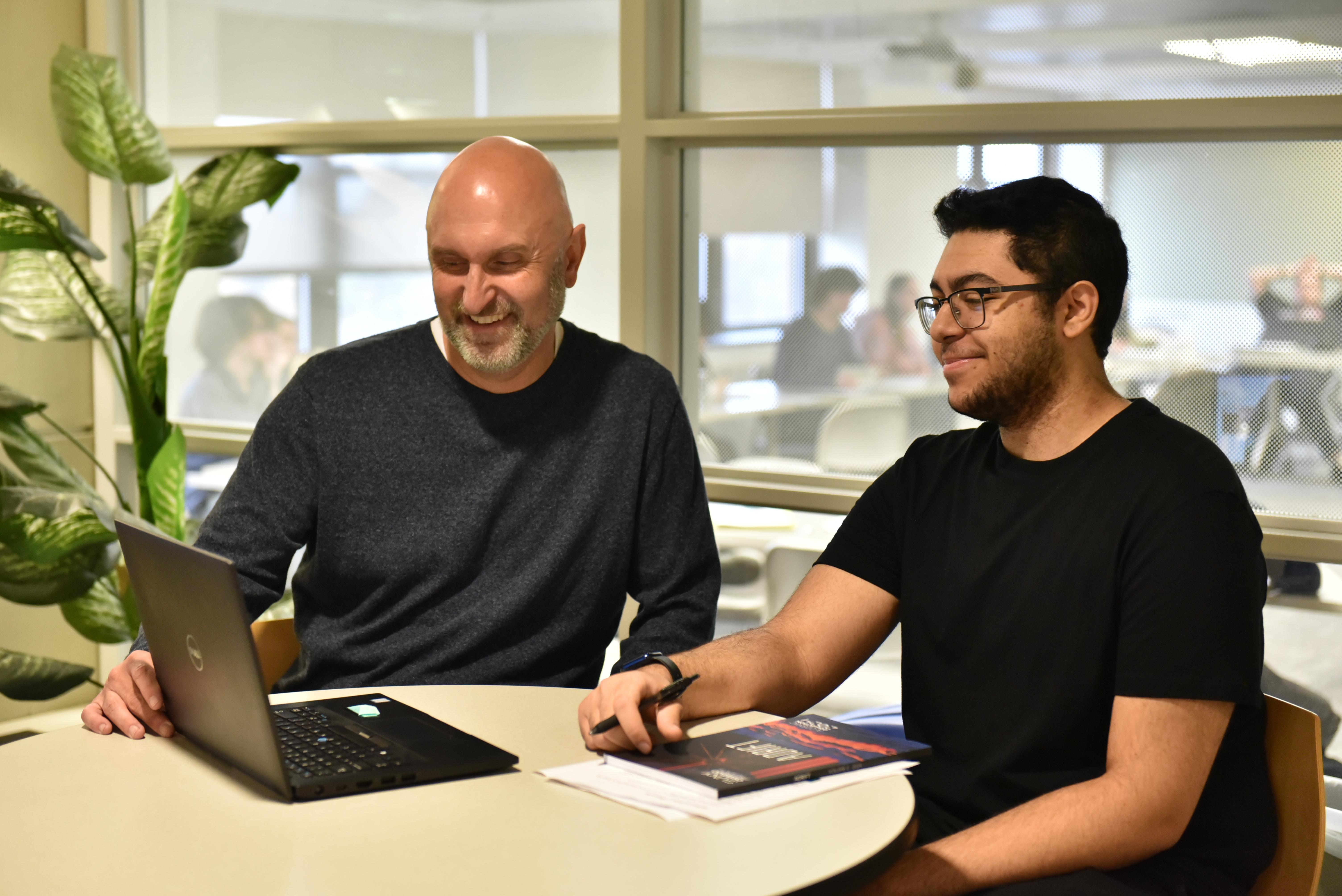 Creative writing student receives feedback from professor during class.