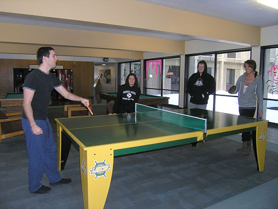 A group of students have fun playing ping-pong in Oneida hall's spacious main floor lounge.