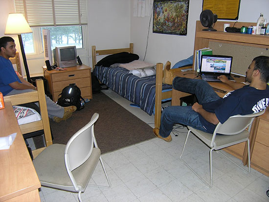 2 males students are hanging out in their room before they leave for Winter Recess.