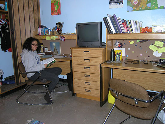 Female student reads at her desk in Scales Hall BEFORE renovations in spring 2017.