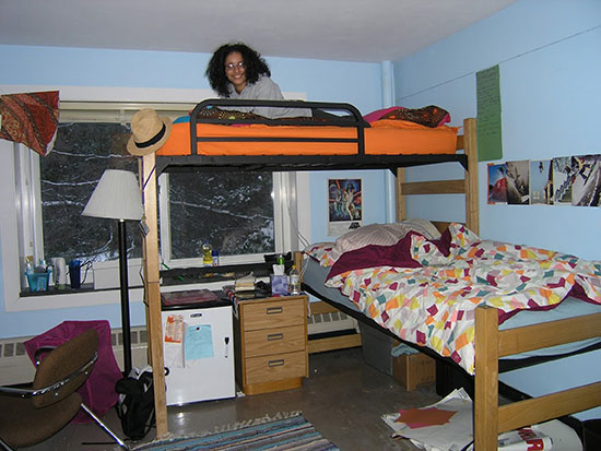 Female student reading on her bunked bed in Scales Hall before spring 2017 renovations.