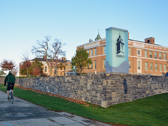 Autumn scene of Sheldon Hall with the new SUNY Oswego signage.