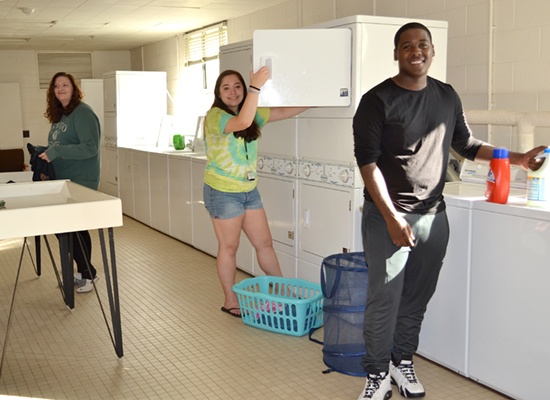Male and female students share the clean and bright laundry room.