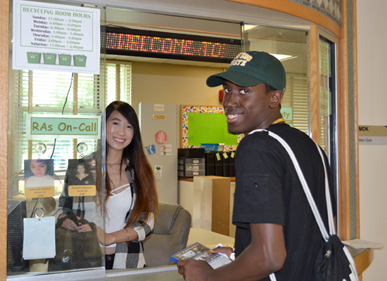 The Desk Attendant helps a resident borrow a movie at Seneca Hall front desk.