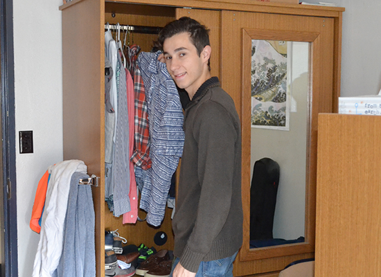 Hart Hall resident pauses for a photo while looking in his armoire for a shirt.