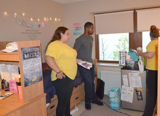 Johnson Hall residents share snacks in their room. Beds are configured in the "default" position.