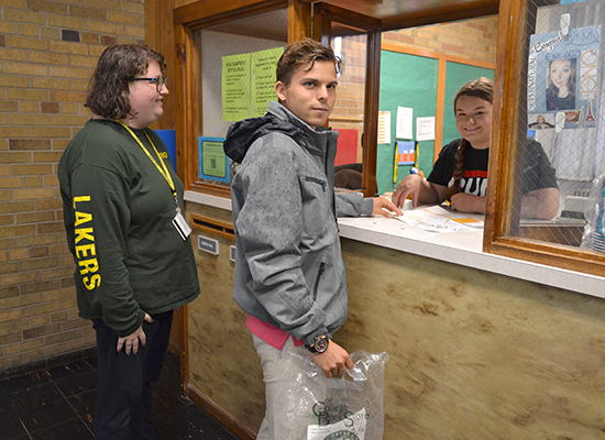 Students converse with the Desk Attendant at the Mackin Complex front desk.