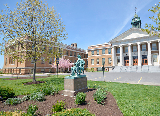 Sheldon Hall exterior in the spring with Edward Austin Sheldon statue.