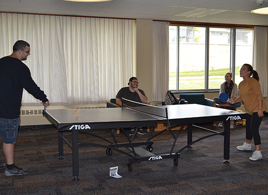 Students in the Funnelle Hall main lounge playing ping-pong.