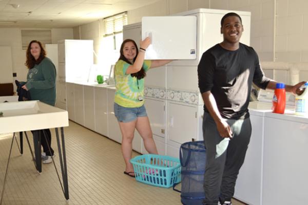 Male and female students share the clean and bright laundry room.