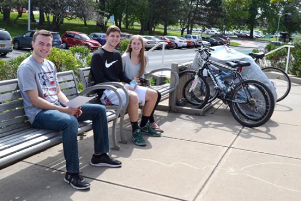 Riggs Hall patio entrance littered with residents' bikes on a sunny day.