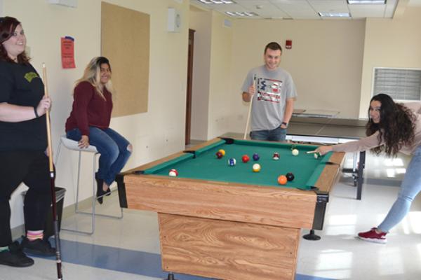 Friendly game of pool in the bright and airy Riggs Hall basement lounge.