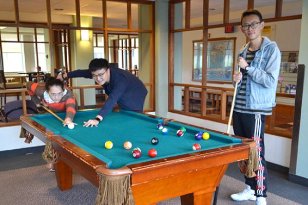 Hart Hall residents play pool in the first floor lounge.