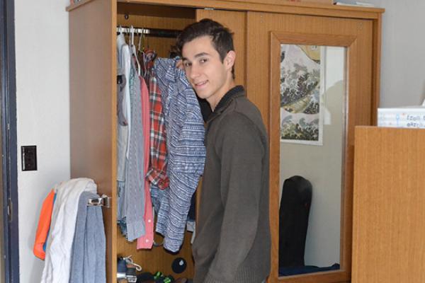 Hart Hall resident pauses for a photo while looking in his armoire for a shirt.