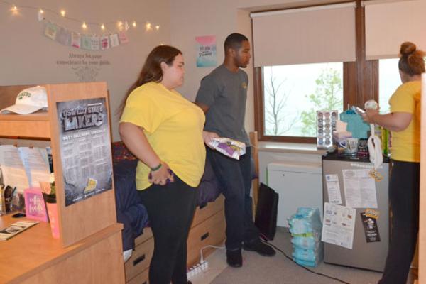 Johnson Hall residents share snacks in their room. Beds are configured in the "default" position.