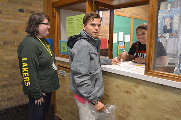 Students converse with the Desk Attendant at the Mackin Complex front desk.