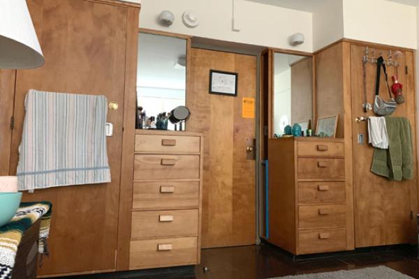 Lonis Hall (part of the Mackin Complex) resident in her single room in front of one or 2 closets.