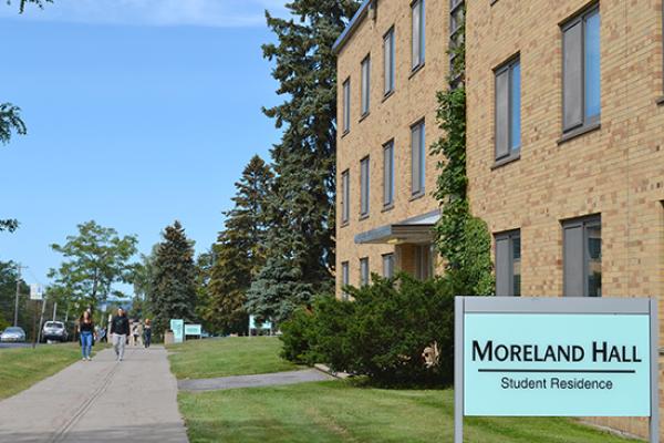 Moreland Hall (part of the Mackin Complex) sign on the side lawn of the building.