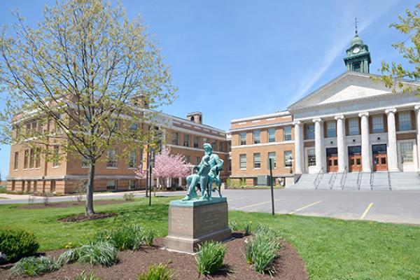 Sheldon Hall exterior in the spring with Edward Austin Sheldon statue.