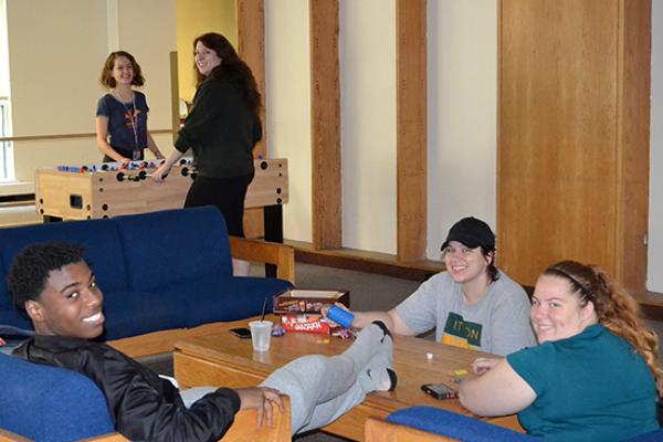 Cayuga Hall students enjoying the lounge area and playing foosball.