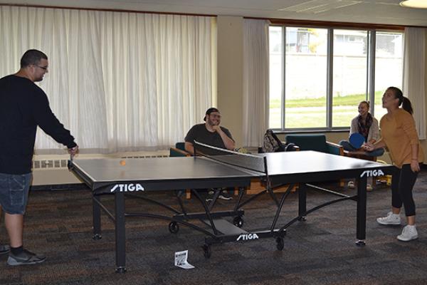 Students in the Funnelle Hall main lounge playing ping-pong.