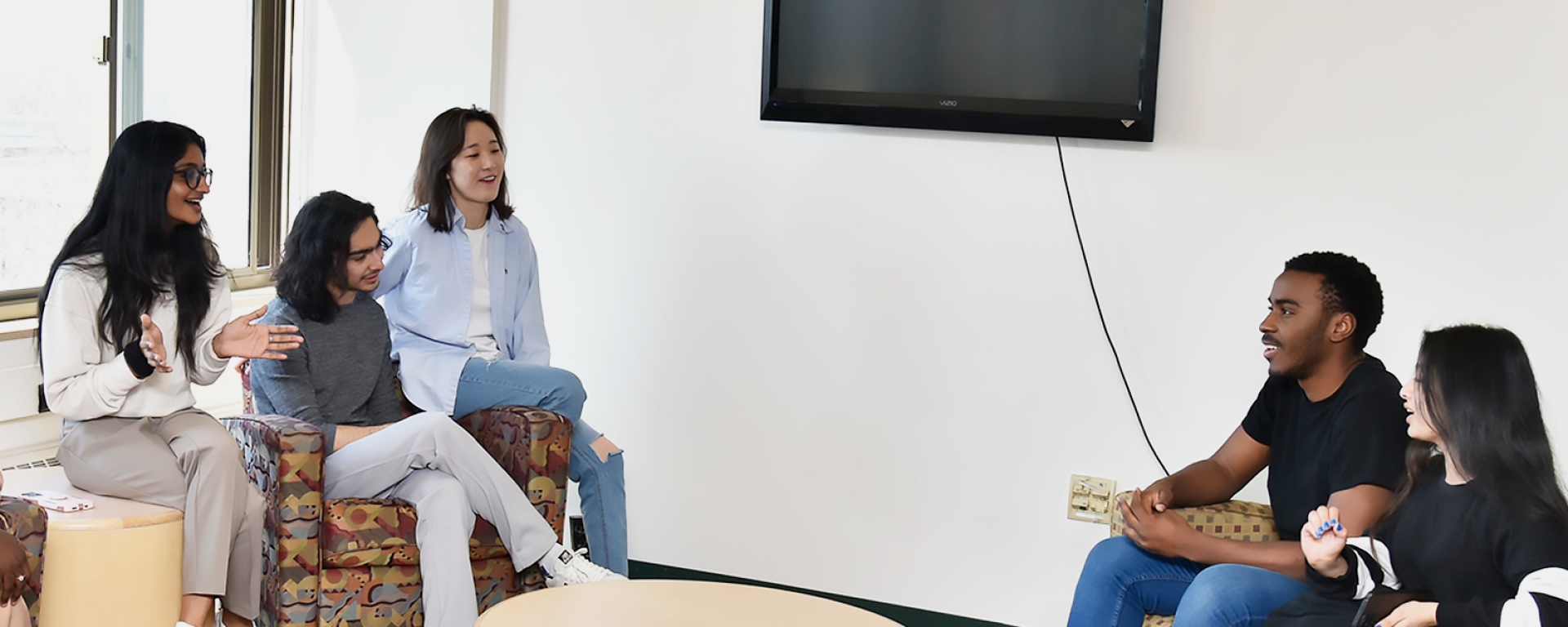 Students gathered in the Hart Hall floor lounge, engaged in conversation