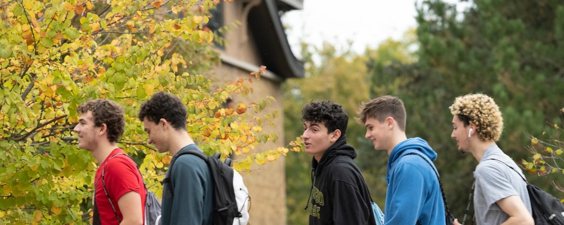 A group of 5 students returning from class and entering into the Lakeside Dining Center through the main entrance