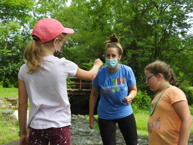 child holding out something to her instructor