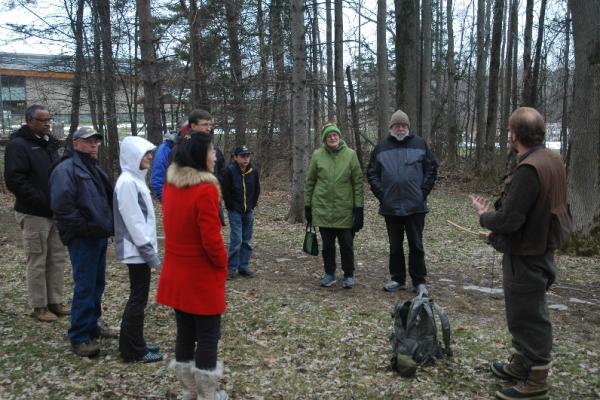 People outside in a circle with one person talking
