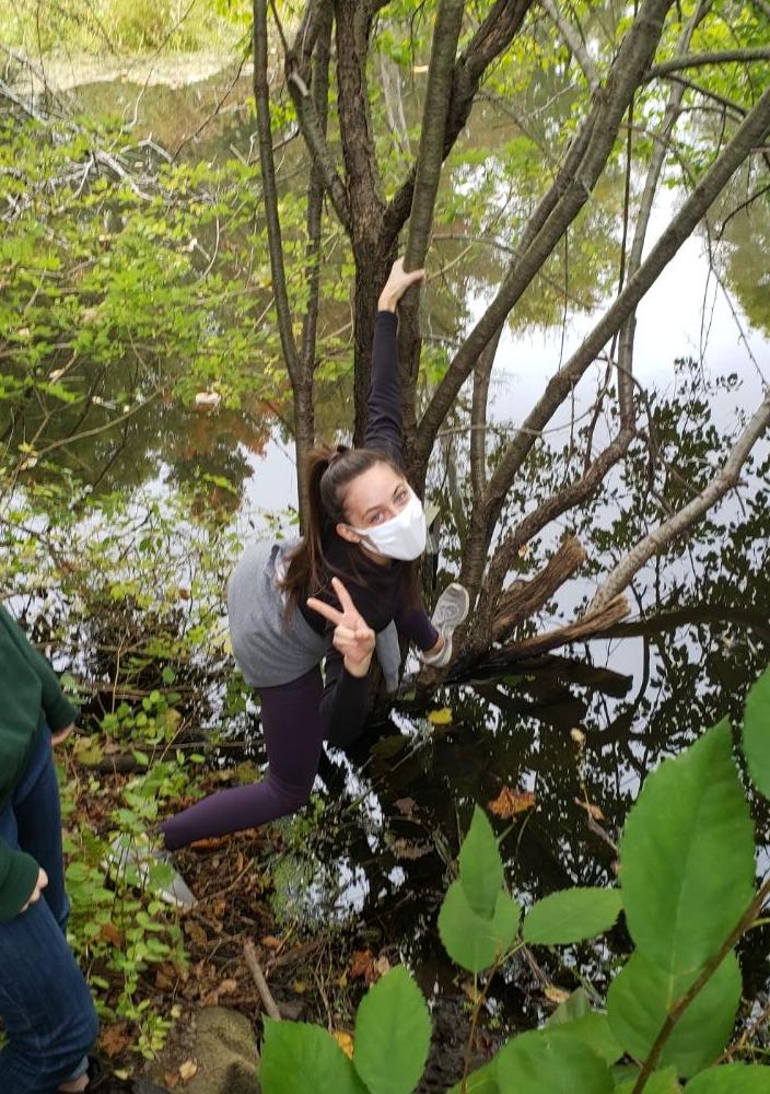 Nicole giving peace sign by a creek