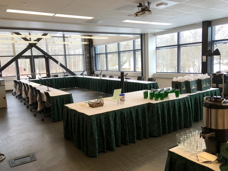 Rooms 123 & 121 set up for a conference, with tablecloths and a u-shaped arrangement of tables