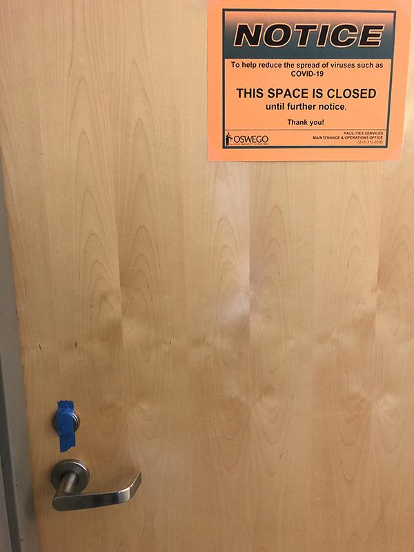 Door with notice sign attached and taped lock to signify it has been cleaned