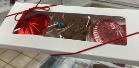 Box of hand-made candies - pink and red foil wrapped hearts and chocolate &quot;Kiss&quot;