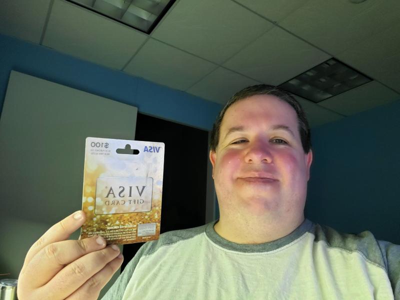 Matt Brooks holding Visa gift card