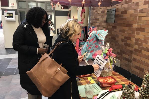 Two women buy tickets at the Baskets of Caring event