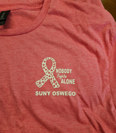 pink t-shirt logo "nobody fights alone, SUNY Oswego" with a white ribbon