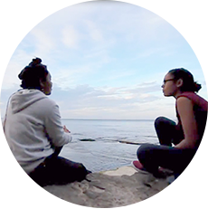 Students sitting next to Lake Ontario