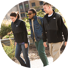Three students walk across campus